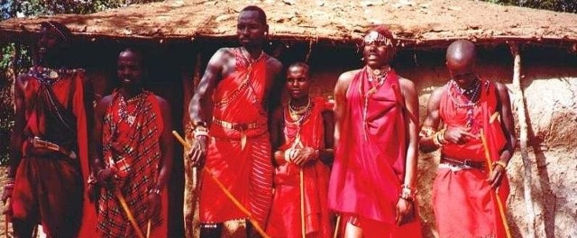 Masajowie w swej wiosce przed jedną z chat