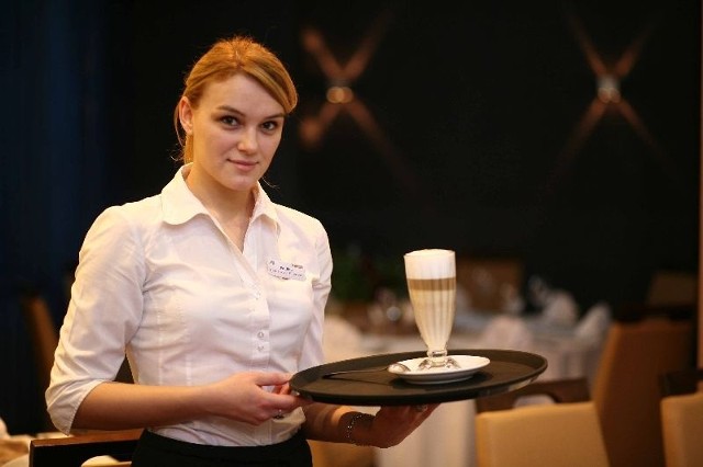 Kawę latte macchiato przygotowaną w restauracji Hotelu Aviator prezentuje Paulina Bochyńska.