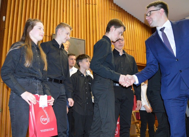 Zwycięski kwintet akordeonowy ze Stalowej Woli prowadzony przez Krzysztofa Garbacza, odbiera gratulacje od jurora.