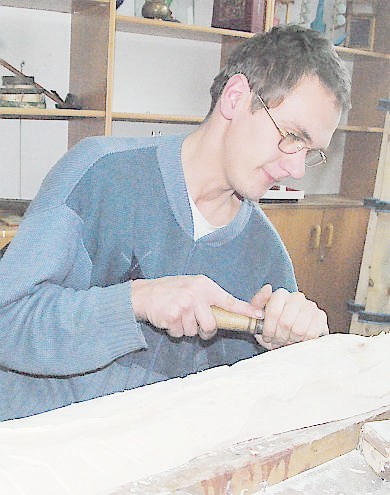 Przemysław Marciniszyn rzeźbi w pracowni stolarskiej