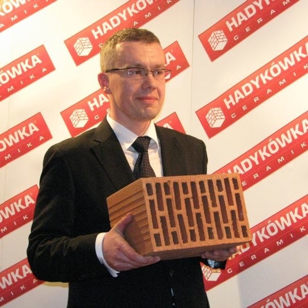 Prezes Beniamin Szczepaniec prezentuje ekologiczną cegłę.