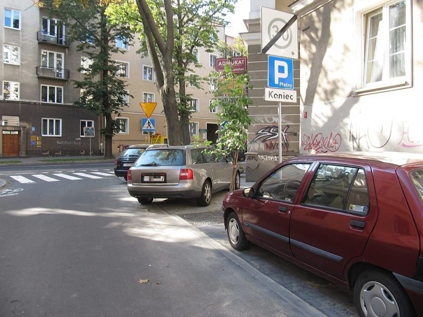 Nielegalnie parkujące samochody znacząco zawężają chodniki,...
