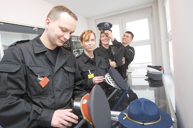 Różne policyjne czapki przymierzają (od lewej): Marcin Karczewski, Anna Nowak, Joanna Wall i Remigiusz Zatwarnicki.