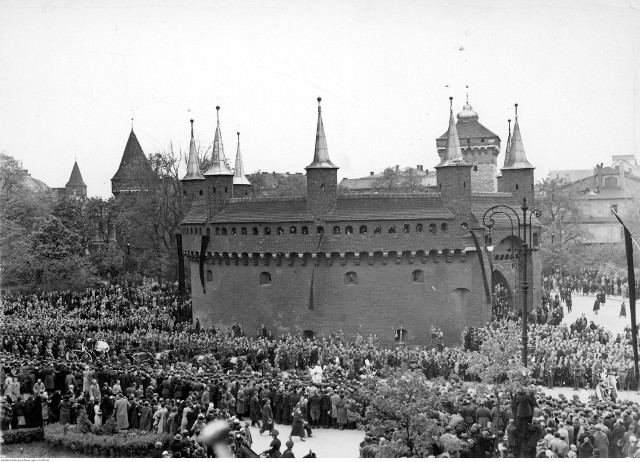 Uroczystości pogrzebowe Józefa Piłsudskiego. Kondukt z trumną przechodzi obok Barbakanu, na którym widać dekoracje żałobne.
