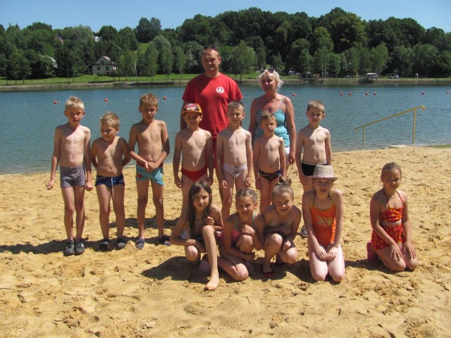 Grupa dzieci z Łapanowa uczestniczących w nauce pływania  organizowanej na tamtejszym zalewie