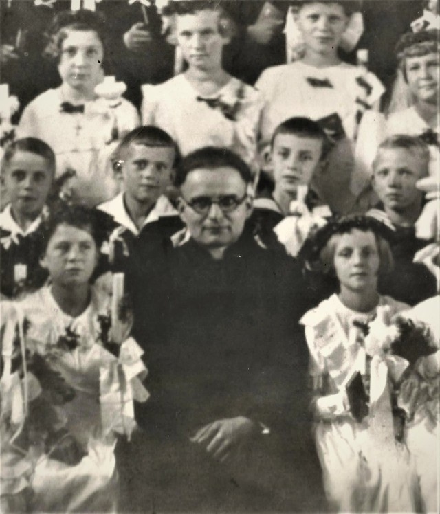 I Komunia Święta Marysi Richert. Rok 1935. Marysia siedzi z prawej strony księdza Mariana Góreckiego