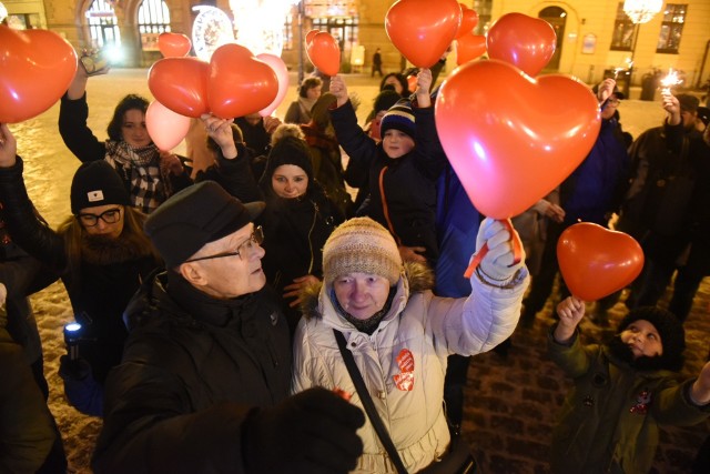 Toruńską starówkę wypełniły dziś (niedziela 27.01) czerwone balony. Torunianie pokazali solidarność z Jurkiem Owsiakiem i Wielką Orkiestrą Świątecznej Pomocy! Po tragedii jaka 13 stycznia wydarzyła się w Gdańsku podczas Finału WOŚP, Jerzy Owsiak zrezygnował z funkcji prezesa Wielkiej Orkiestry Świątecznej Pomocy. Jednak liczne głosy płynące z całej Polski nakłoniły głównego dyrygenta Orkiestry do powrotu. - Gdy usłyszałem, co mówi wspaniała, kochana żona Pawła Magda, która powiedziała, żeby Orkiestra nadal grała tak, jak gra i kiedy podczas tej mszy usłyszałem parę bardzo ważnych słów, a masa ludzi, podchodząc do mnie prosiła, żeby Orkiestra była w takim kształcie, jak była, pomyślałem sobie, że to życie się odradza na nowo. Tak, będę grał z Orkiestrą. Tak, będę prezesem Fundacji - mówił Jerzy Owsiak. Akcja #muremzaowsiakiem ma zasięg ogólnopolski. Podobne manifestacje odbyły się już m. in. w Krakowie czy w Poznaniu. Charakterystycznym atrybutem są czerwone balony, często w kształcie serca. "Kochani niech będzie nas widać. Niech każdy zabierze ze sobą czerwony balonik, latarkę/telefon. Wzniesiemy nasze światełko do nieba połączone z czerwonymi balonami" - możemy przeczytać w opisie wydarzenia na Facebooku. Czytaj też:Pożar w Ciechocinku ZDJĘCIAStarówka i Motoarena nocą. Unikalne zdjęcia z dronaKobiety poszukiwane przez policję w Kujawsko-Pomorskim