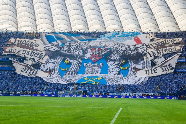 Od momentu, kiedy finały Pucharu Polski są rozgrywane na Stadionie Narodowym, Lech Poznań wystąpił na obiekcie w stolicy już trzykrotnie. W spotkaniu z Rakowem Częstochowa, które odbędzie się już 2 maja, stanie się to po raz czwarty. Za każdym razem za ekipą Kolejorza jeździ ogromna liczba kibiców, którzy tworzą niezapomniany spektakl na trybunach. W tym roku może jednak zabraknąć efektownych opraw ze strony fanów, ponieważ decyzją władz miasta Warszawy nie będzie można wnieść flag o wymiarach większych niż 2m x 1,5 m. Przypominamy, jak prezentowały się poprzednie finały z udziałem kibiców niebiesko-białych na Stadionie Narodowym w Warszawie.Zobacz kolejne zdjęcie z opraw fanów Lecha --->