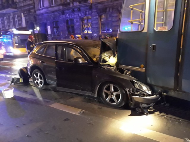 Samochód osobowy audi uderzył w tył tramwaju. Przód samochodu wbił się pod wagon.