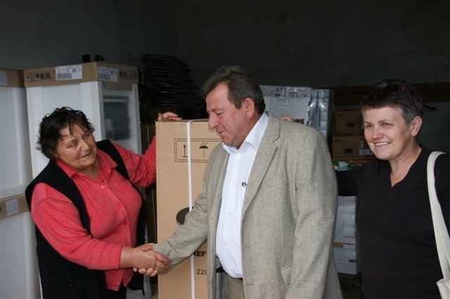 Burmistrz Krzysztof Wrzesiński przekazuje lodówkę Krystynie Ciastko. Obok Kazimiera Łączkowska