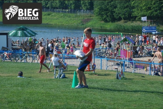 Oto jedna z przeszkód na trasie Biegu Herkulesa. Zawodnik biegnie brzegiem zalewu, dobiega do ustawionych worków wypełnionych piaskiem (o wadze 15 kg), chwyta jeden i niosąc go, biegnie do pachołka oddalonego o 20 m, obiega pachołek i odnosi worek na miejsce.