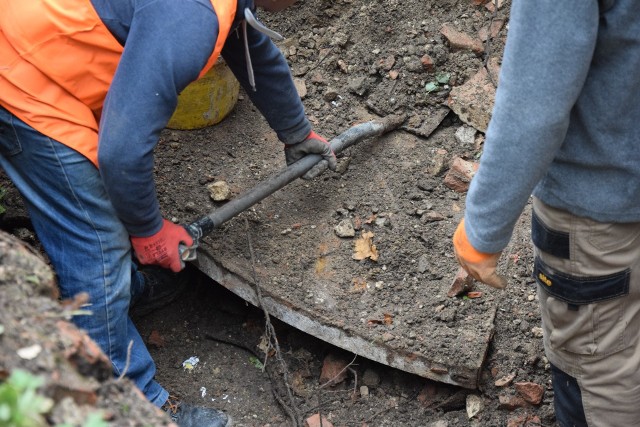 Nz. widoczny górny fragment stalowego skrzydła drzwi. Prace prowadzone są ręcznie.