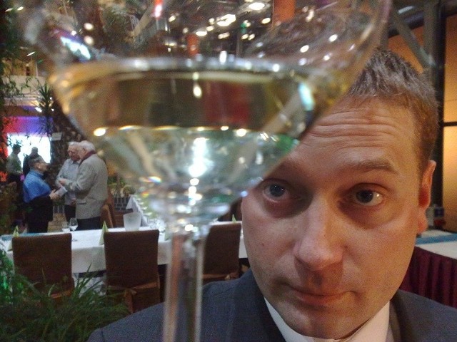 Łukasz Chrostowski z Mierzęcina z winnicy Equus pokazuje swoje wino.