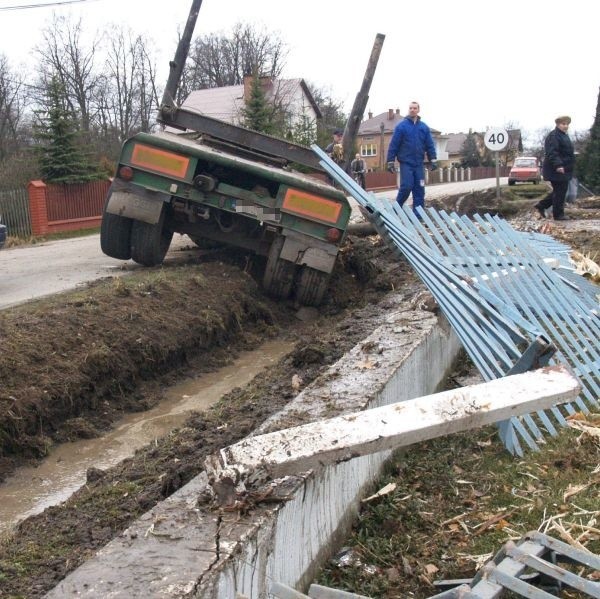 Przyczepa z drewnem skosiła płot posesji stojącej przy drodze.