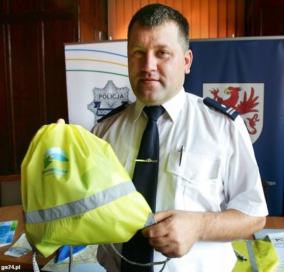 Policja już szykuje się do następnej akcji "Bezpieczna droga do szkoły". Nadkomisarz Grzegorz Sudakow prezentuje przygotowane dla uczniów odblaskowe worki na obuwie.