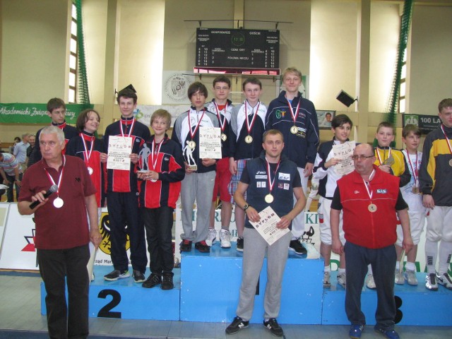 Podium drużynowej rywalizacji florecistów. Z lewej wicemistrzowie Polski z Kolejarza Wrocław i ich trener Zbigniew Koerber (z mikrofonem). Z prawej brązowa ekipa Wrocławian i jej opiekun Piotr Stasiewicz.