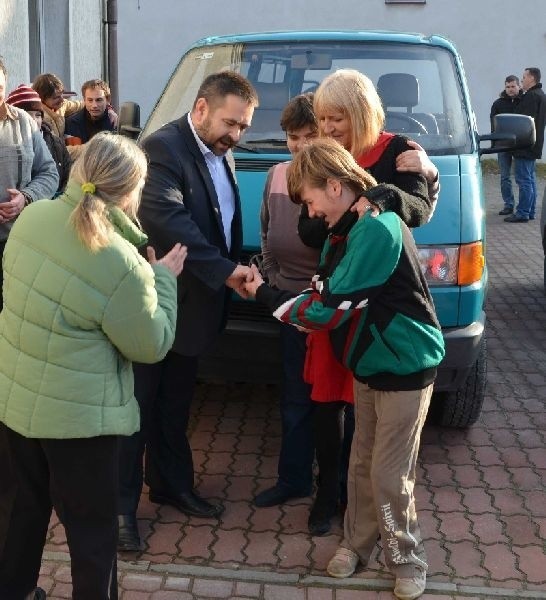 Podopieczni Środowiskowego Domu Samopomocy z radością oglądają samochód, którym będą dojeżdżać na zajęcia w placówce i dziękują wójtowi Tadeuszowi Dąbrowie.
