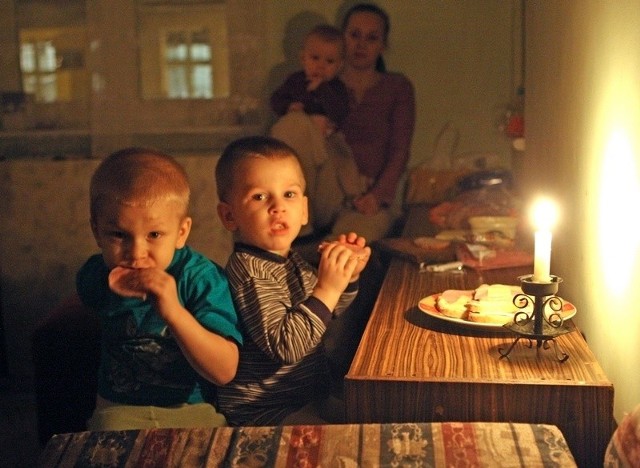 Ewelina Żaczek w ciemnym pokoju ze swoimi dziećmi.
