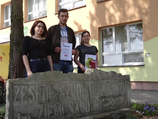 Monika Banduch, Marcin Drzazga i Paulina Nowakowska z dyplomami przed szkołą w Sandomierzu.