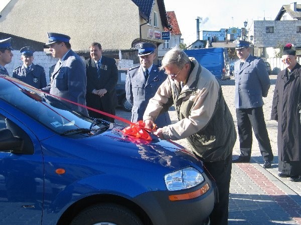 Wstęgę na podarowanym przez samorząd  chevrolecie przecina burmistrz Marek Jankowski.  W tle komendant powiatowy Janusz  Gierszewski, p. o. komendanta gminnego Robert  Szyszka oraz zastępca komendanta  wojewódzkiego Marek Łukasiewicz.