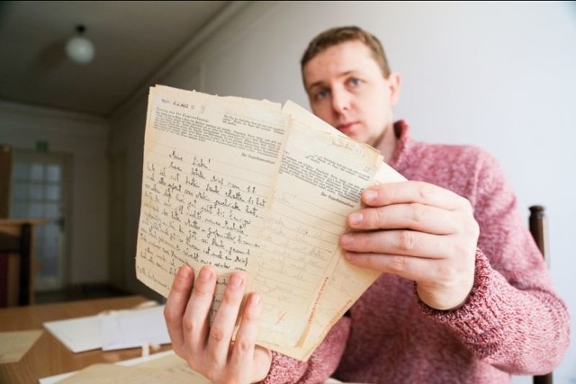 Tomasz Fiedorowicz, pracownik Archiwum Państwowego pokazuje korespondencję księży Naruszewiczów z niemieckiego obozu koncentracyjnego
