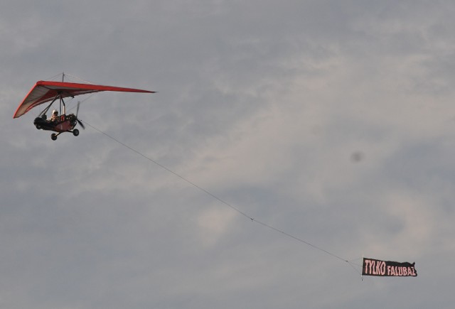 Tuż przed rozpoczęciem derbów żużlowych w Gorzowie, nad stadionem miało miejsce nietypowe zjawisko. Przez kilka minut krążyła tu motolotnia z przyczepionym napisem "Tylko Falubaz". Jak zareagowali gorzowscy kibice?Tego nikt się nie spodziewał. Na około pół godziny przed rozpoczęciem derbów żużlowych nad gorzowskim stadionem pojawiła się motolotnia z napisem "Tylko Falubaz". Kibice Stali Gorzów zaczęli gwizdać. Jak nietrudno się domyśleć, kibice Falubazu przywitali tę niecodzienną wizytę motolotniarza gromkimi brawami.Wkrótce okazało się, że napis na motolotni przygotowali... gorzowianie. Teraz przemknęła ona z napisem: "Przy wielkiej Stali to Tylko Falubaz".Przeczytaj też:  Cash Broker Stal Gorzów - Ekantor.pl Falubaz Zielona Góra [RELACJA LIVE]