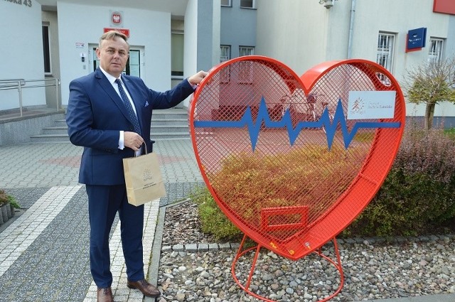 Piotr Leśnowolski, wójt gminy Jedlnia-Letnisko zachęca do udziału w akcji pomocy i wrzucaniu plastikowych nakrętek do specjalnego pojemnika w kształcie serca.