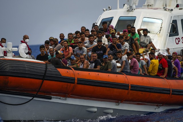 Imigranci - w większości z Tunezji - na pokładzie włoskiej łodzi na Lampeduzie. Zdjęcie z sierpnia 2022 r.