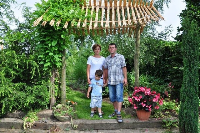 Magdalena i Paweł Płazowie z synkiem Filipem w ogrodzie.