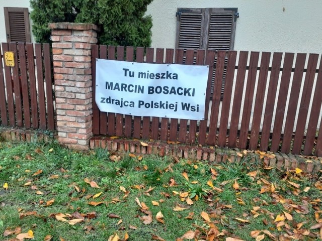 Banery z obraźliwymi hasłami na płocie senatora Marcina Bosackiego.
