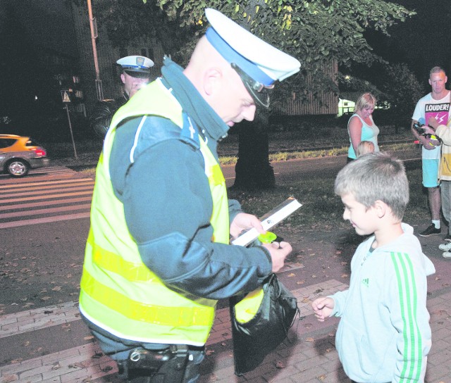 Na razie policjanci rzadko wlepiają mandaty. Częściej pouczają i wręczają odblaski pieszym (na zdjęciu akcja z Koszalina).