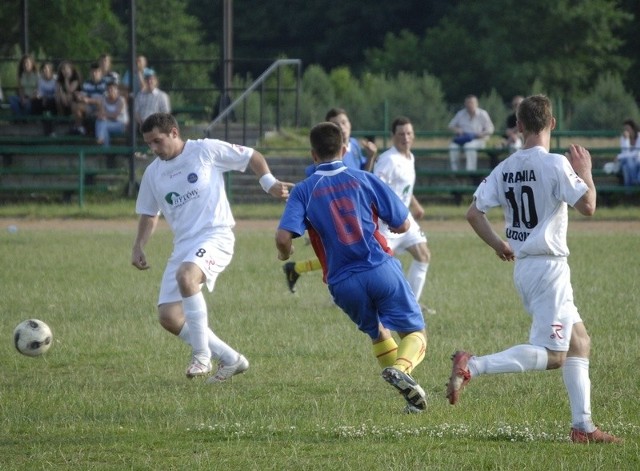 Piłkarze Uranii (białe stroje, przy piłce Semeniuk) dopingowani w Smołdzinie przez grupę swoich kibiców, wygraii i zagrają w okręgówce.