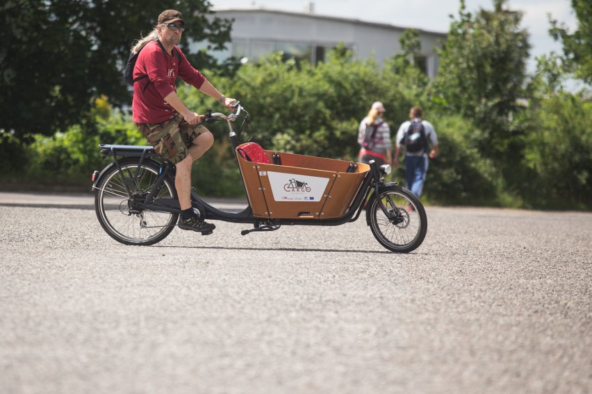 Dwukołowy rower cargo Babboe City-E ma otwartą drewnianą...