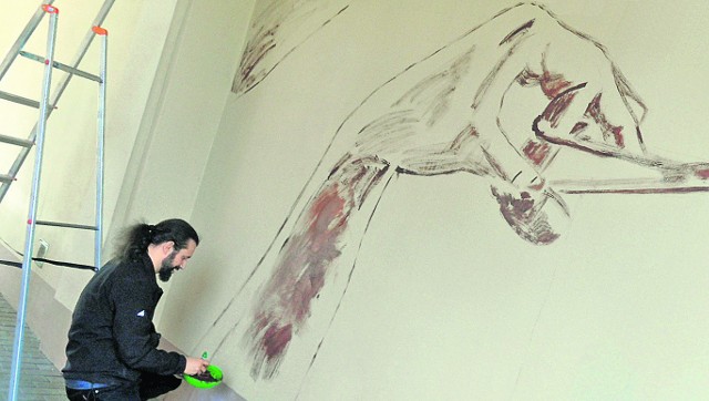 Jacek Sztuka maluje Cyklopa w bramie alei Najświętszej Maryi Panny. Mural ma być gotowy do 9 czerwca tego roku
