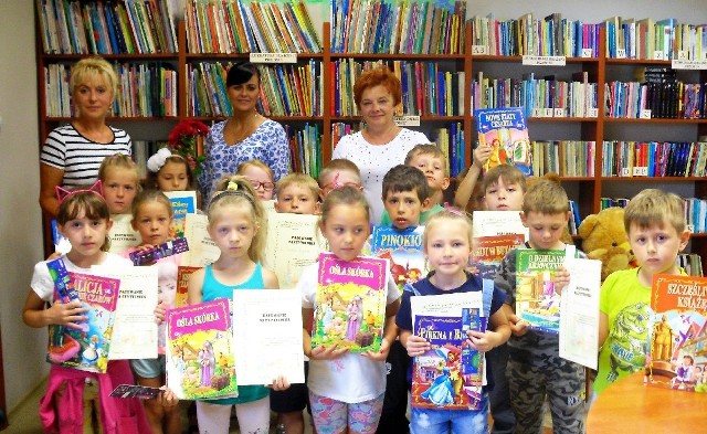 Pamiątkowe zdjęcie nowych czytelników z bibliotekarkami i opiekunkami przedszkolnymi