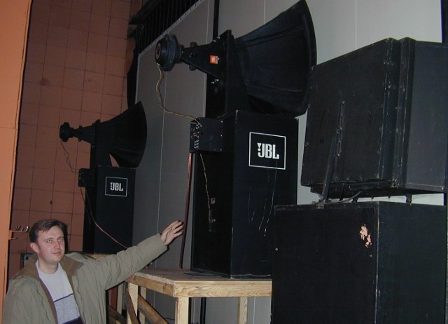 Marcin Cieślewicz pokazuje centralny głośnik, znajdujący się za ekranem.