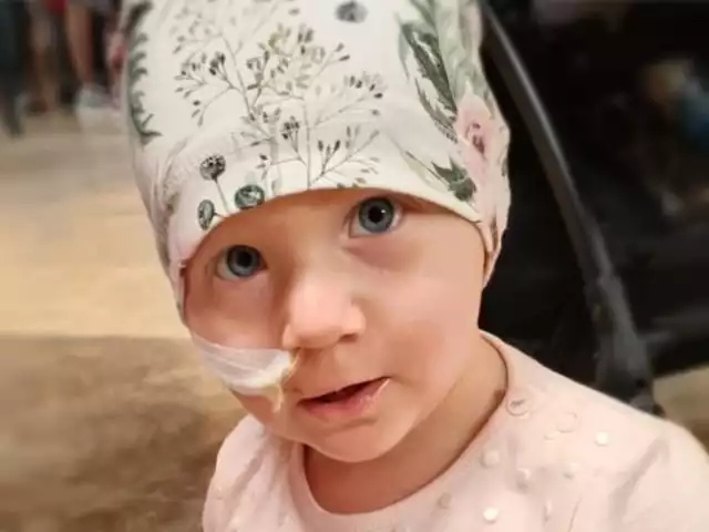 2-letnia Tosia Kołtuniak z Kielc od urodzenia była okazem zdrowia. Wszystko skończyło się, gdy dziewczynka po prostu nie przewróciła się na bok. Raczkujące już, aktywne dziecko zaczęło nagle bezradnie ciągnąć nóżki po dywanie. A potem przyszła diagnoza, która zmieniła wszystko. Tosia ma nowotwór - neuroblastomę przykręgosłupową.