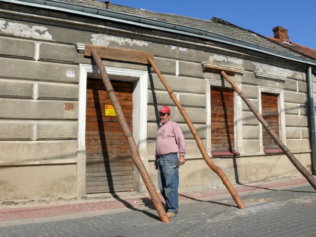 Antoni Andrusik przy podpartej czołowej ścianie zrujnowanego domu.