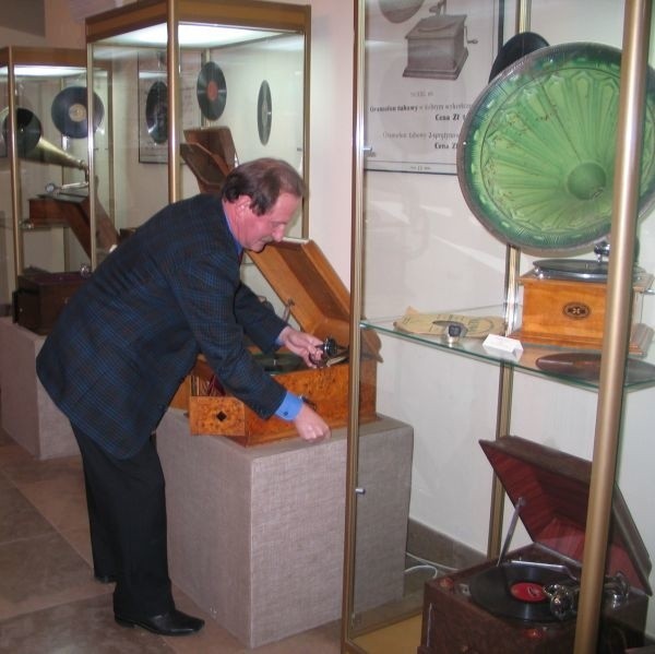 Adam Zwola, organizator wystawy nakręca jeden z gramofonów. 