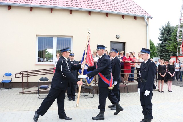 Prezes OSP w Nowej Niedrzwicy Michał Wilczyński przekazuje sztandar strażakom z pocztu.