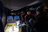 Mróz w Krakowie. Wieczorny autobus wozi pomoc dla bezdomnych. Na przystankach: ciepło, kanapki, termosy, odzież