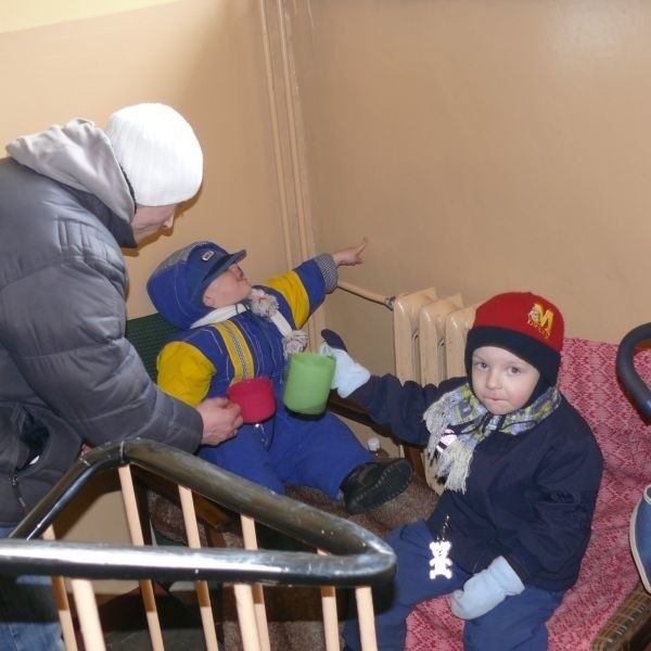 Rodzina z dwójką małych dzieci koczująca na klatce schodowej w oczekiwaniu na gminne lokum.