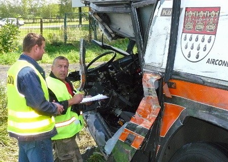 Czołowe uderzenie sprasowało kabinę kierowcy autokaru. Wrak oglądają technicy z KPP w Międzyrzeczu (od lewej) mł. asp. Mirosław Kopyściański i asp. sztab. Zdzisław Smoleń.