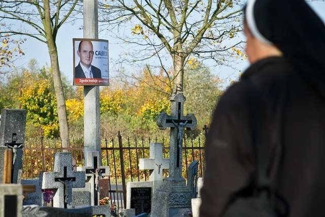 W Czarnowie marszałek spogląda z plakatu na odwiedzających cmentarz. Widać go też od strony ulicy