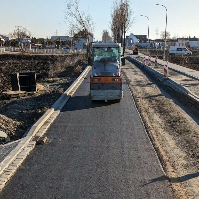 Robotnicy kładą już asfalt na przebudowywanej ul....