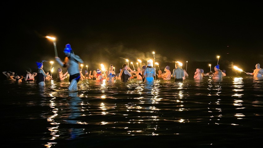 Nocne morsowanie w Jeziorze Tarnobrzeskim z ogniem. Morsy spędziły wieczór w zimnej wodzie, w blasku pochodni. Zobacz zdjęcia 