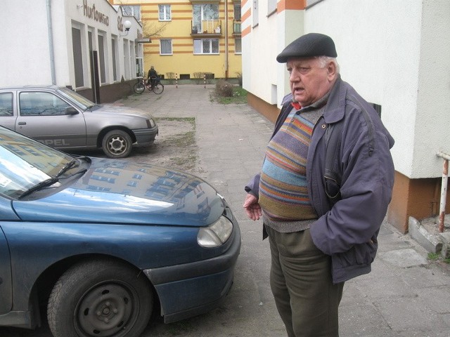 Antoni Wujda pokazuje, jak blisko jego okien na parterze stoją samochody osobowe