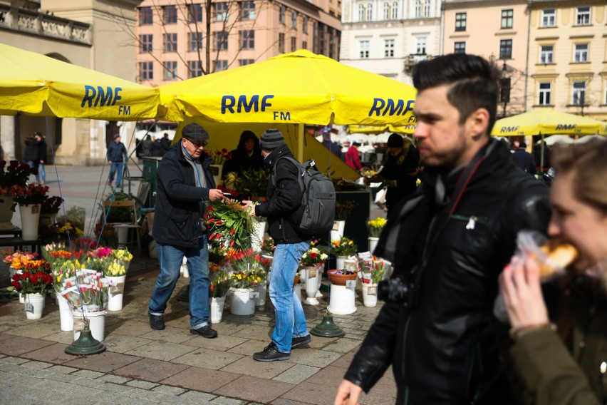 Panowie kupują kwiaty na Dzień Kobiet u kwiaciarek na Rynku