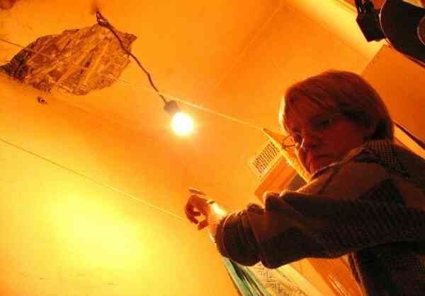 Krystyna Gęboczyk pokazuje odpadający tynk i pękający sufit w mieszkaniu jej mamy, Edyty Michalak.