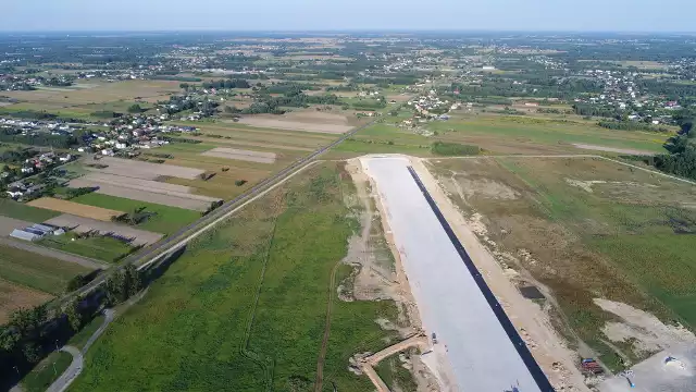 Część wschodnia lotniska z widoczną końcówką nowozbudowanego pasa startowego oraz drogą powiatową, która ma być "przełożona" bardziej na północ.